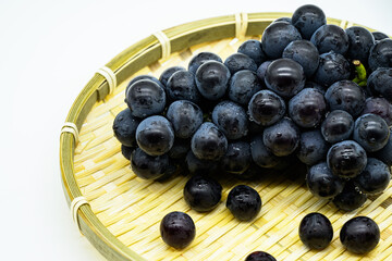 대나무 바구니에 담긴 검정색 포도 