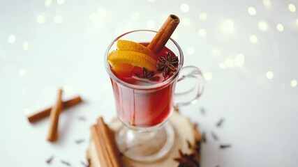 Warm winter drink with orange slices, cinnamon sticks, and star anise on wooden base - Powered by Adobe