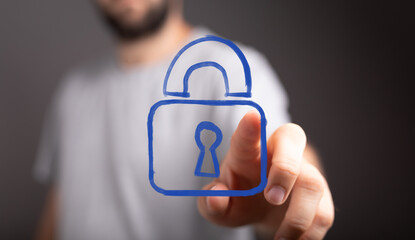 A man's hand interacting with a digital padlock icon, symbolizing data protection, internet...