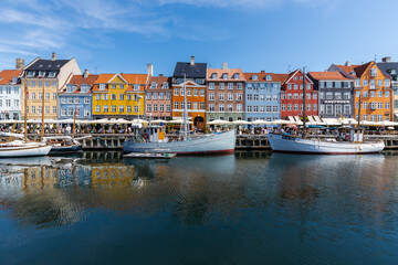 Obraz premium Copenhagen, Denmark 07-20-2025 The historic waterfront Nyhavn is a canal in the centre of Copenhagen and known for its brightly colored buildings, historic ships and the author Hans Christian Andersen