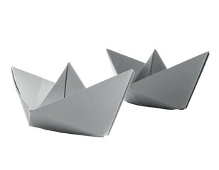 Two folded paper boats sit side-by-side, against a black background