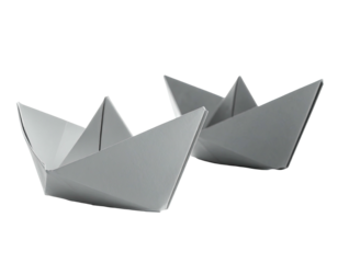 Two folded paper boats sit side-by-side, against a black background