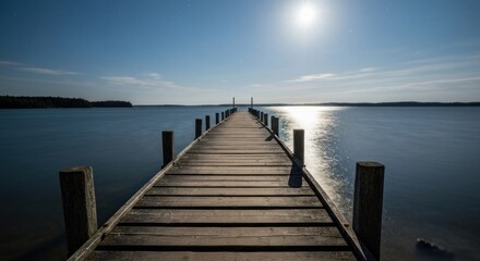 Fototapeta premium Wooden pier extends into serene lake at night. Full moon