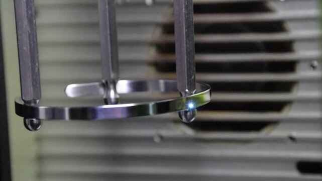 Macro video of laser engraving on a bracelet using a rotary attachment. The footage shows the precision process of creating detailed personalized designs on metal jewelry. Perfect for illustrating mod