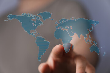 Hand pointing at a world map, symbolizing global reach, connection, and international business.