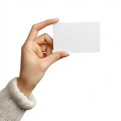 Fototapeta premium A person's hand holding a blank card with a soft sweater sleeve visible. The card is plain and ready for customization