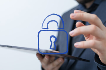 Close-up of a person holding a tablet, interacting with a blue digital padlock icon, symbolizing...