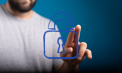 Man's hand touches a glowing digital padlock icon, symbolizing cyber security, data protection, and...