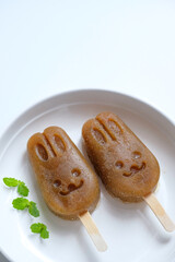 Homemade apple lemon mint popsicles isolated on a white plate