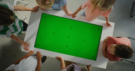 Pupils Study in Modern Classroom on Digital Screen With Chromakey Layout. Green Screen Fill For Educational Content or Interactive Visual Effects. Modern Technology, Innovation. Rotating Top View.