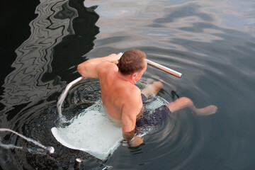 Fototapeta premium A disabled man slides into the water from a special platform