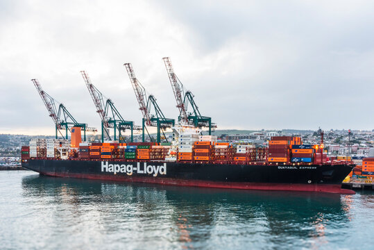 San Antonio, Chile - Cargo ship owned by "Hapag Lloyd" at a container terminal with numerous stacked shipping containers on its deck. 