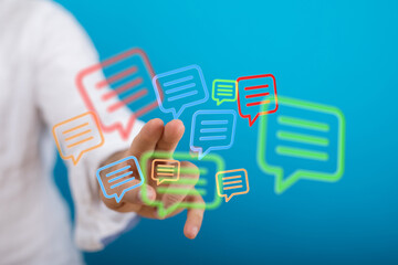 Hand touching holographic chat bubbles. Depicts online communication, notifications and digital messaging in modern technology.