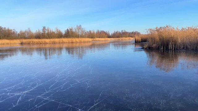 Point Of View ice skating on a frozen lake in nature during a beautiful winter day in Holland.