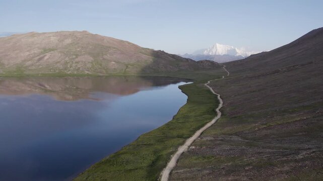 Sheosar Lake and winding road in Deosai National Park with Nanga Parbat peak in the distance