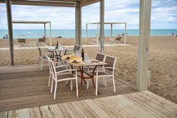 Beach restaurant at Marina di Castagneto, Tuscany, Italy, with a wooden pergola. In the background...