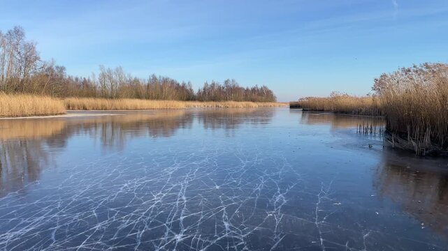 Point Of View ice skating on a frozen lake in nature during a beautiful winter day in Holland.