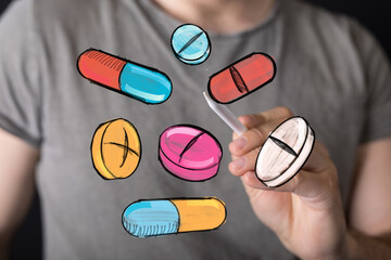 Image of a hand drawing various colorful pills and capsules.  Perfect for healthcare, medicine, or pharmacy concepts.