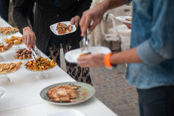 Guests select delicious food from an elegant buffet spread at a sophisticated private party event celebrating a special occasion with friends and family enjoying a delightful culinary experience