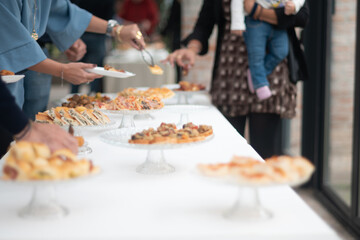 Elegant private party guests enjoying a delightful buffet spread with an array of delicious appetizers and finger foods set on a beautifully decorated table awaiting selection and consumption at a