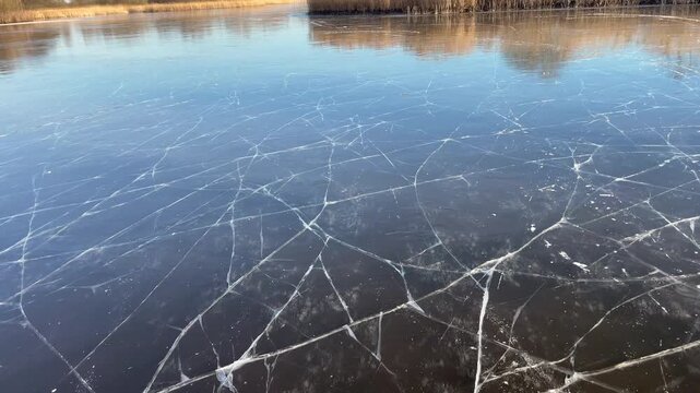 Point Of View ice skating on a frozen lake in nature during a beautiful winter day in Holland.