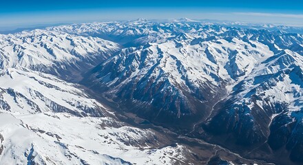 Aerial view of snowy mountains under a clear blue sky