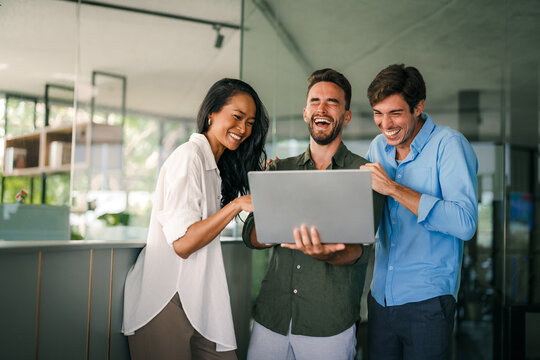 Group of young multi-ethnic startup business team collaborating on project in modern office