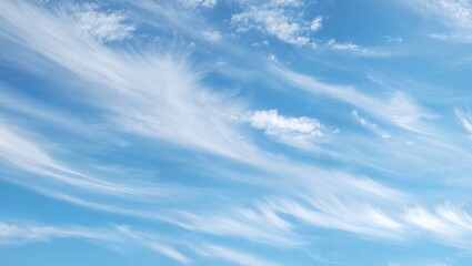 High altitude wispy cirrus clouds streaking across bright blue sky with delicate featherlike vapor trails and thin white filaments creating soft sunlight diffusion
