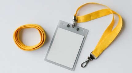 A clear, blank ID badge sits on a white surface next to a coiled yellow lanyard. The lanyard is also extended