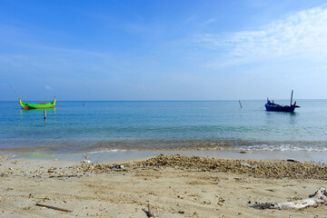 tropical beach with fishing boats rest under a bright blue sky, fisherman village © Fais