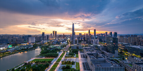 Modern city skyline and financial district with a central park at a dramatic sunset in Ningbo.