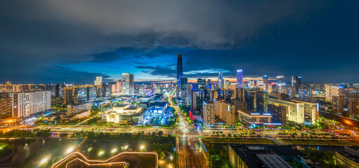 Obraz premium Aerial view of the modern city skyline with illuminated commercial buildings and busy traffic at night in Ningbo.