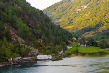 Obraz premium The small Norwegian village of Hellesylt, at the head of the Sunnylvsfjorden, a branch of the Storfjorden and the more famous Geirangerfjord, which is a famous cruise stop for a daytrip in the county