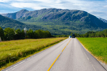 Naklejka premium The village of Grodas in Norway, which is on the Hornindalsvatnet lake, the deepest lake of Europe and surrounded by amazing lush nature of green fields, impressive rock formations and mountains