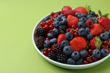 Different ripe berries on green background, closeup. Space for text