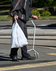 Old man walks on the street with a walker