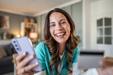 Happy young woman smiling on smartphone video call