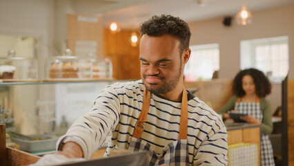 Young Man With Down Syndrome Stocking Shelf With Bread In Food Shop