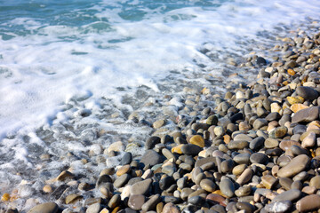 Beautiful view of wavy sea and pebbles on beach, closeup