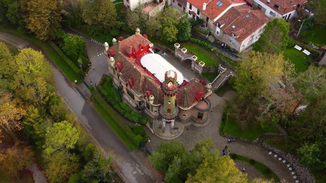 Aerial view of Comillas, Cantabria, Spain, showcasing its famous landmarks including the Capricho de Gaudi, the Pontifical University, and the historic town center with red-tiled roofs and coastal
