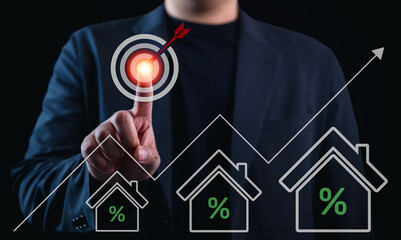 Real estate investment strategy concept. Businessman touching target icon with house and interest rate symbols. Mortgage, housing market, finance, and property business concept.