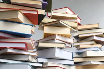 Many books against light grey background, closeup