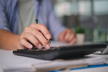 Accountant calculating finance data on calculator, working on business documents, audit report, money management, tax season, investment analysis, financial planning with paperwork at the office.