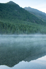 Shoreline of Lower Multinskoye lake on a misty morning, glacial lake in the Altai mountains, Russian Federation