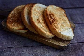 White bread toasted on an outdoor Grill on wooden table