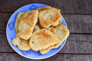Traditional Bulgarian home made deep fried  patties  covered with sugar  оn rustic backgroud.Mekitsa or Mekica,  on wooden  rustic  background. Made of kneaded dough that is deep fried 