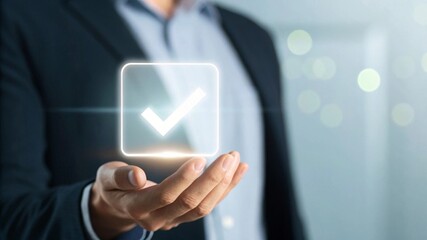 Hand holding transparent holographic display with glowing checkmark icon in business environment for task completion concept