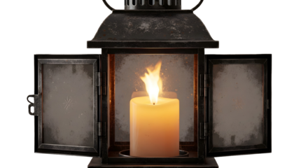 An antique black metal lantern with its doors open, revealing a single lit candle casting a warm glow.