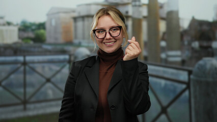 Woman smiling with heart gesture stands outdoors near roman ruins, showcasing joy in historic city...