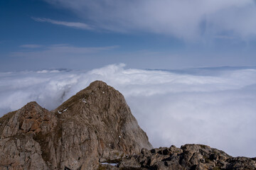 Dramatic high mountain landscape with snow, rocks and low clouds